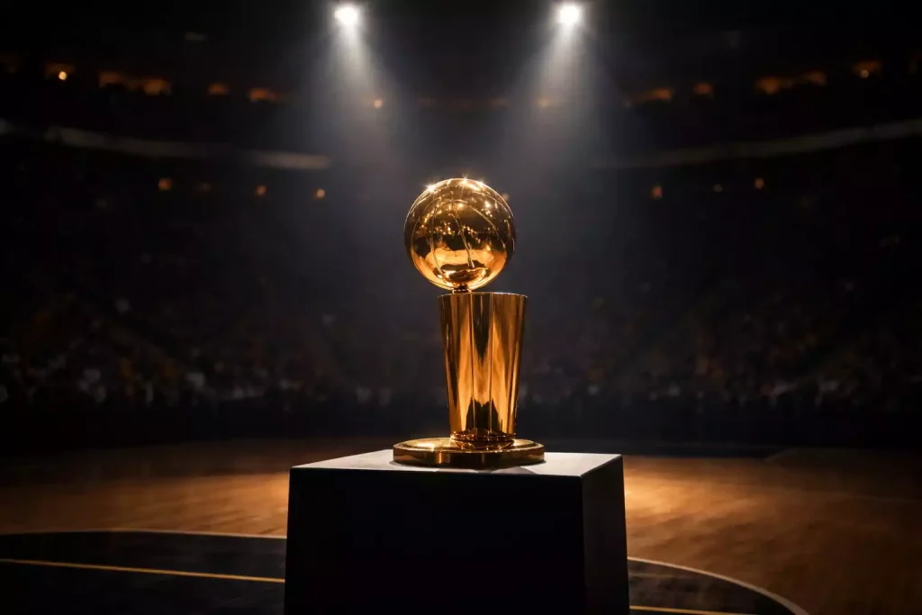 De NBA-kampioenstrofee glinstert onder spotlichten op een podium in een donkere arena