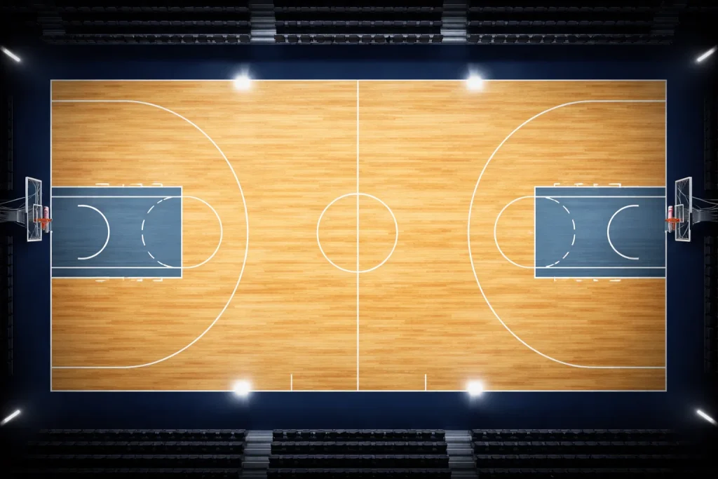 Leeg NBA-basketbalveld van bovenaf gefotografeerd met felle arenaverlichting en geschilderde lijnen